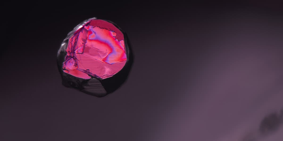 Iridescence on (probably chacopyrite) crystal; no heat Mozambique ruby; A-001-1085; EBH