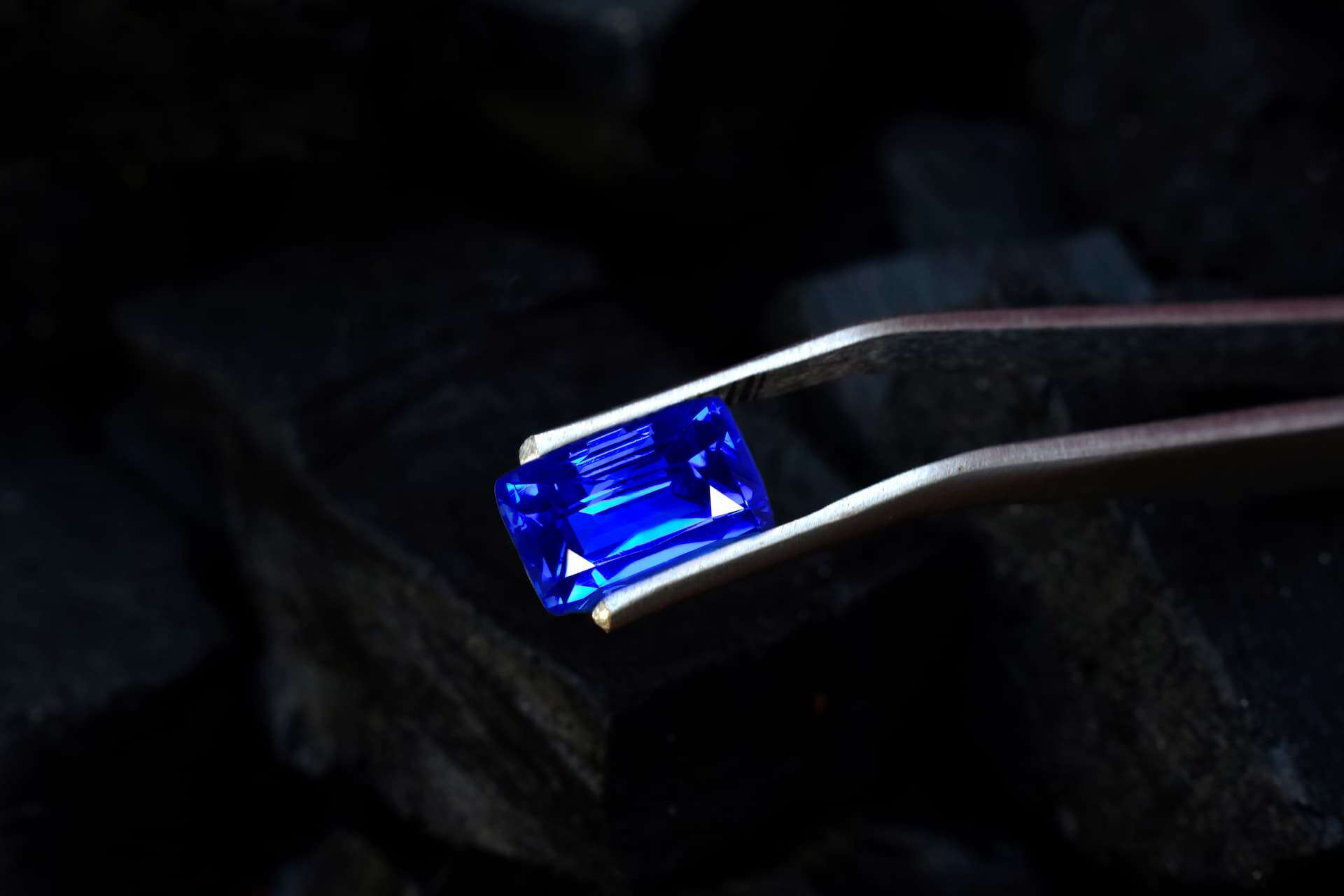 Blue sapphire gemstone in a tong