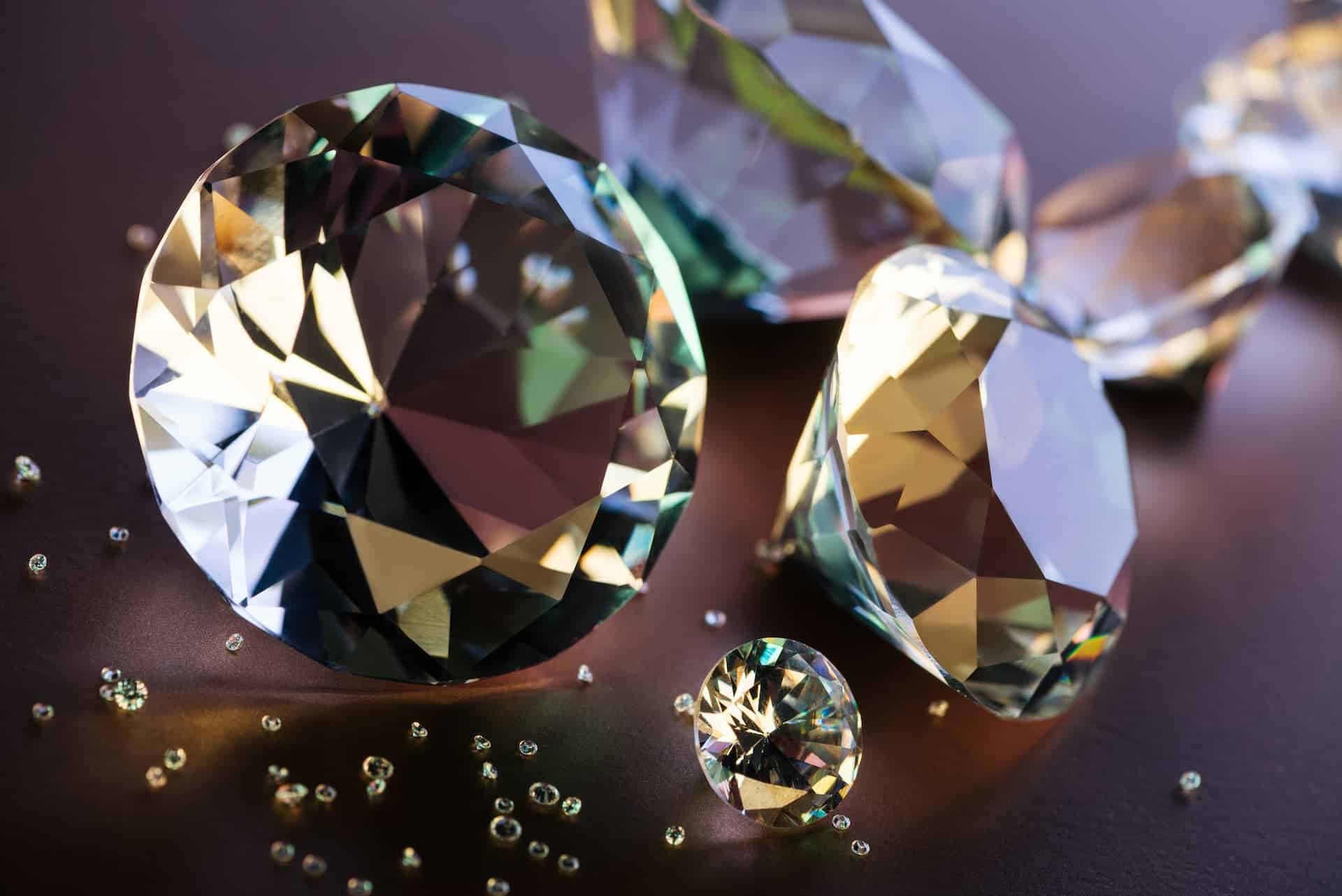 Close up of various size beautifully lit diamonds on brown background