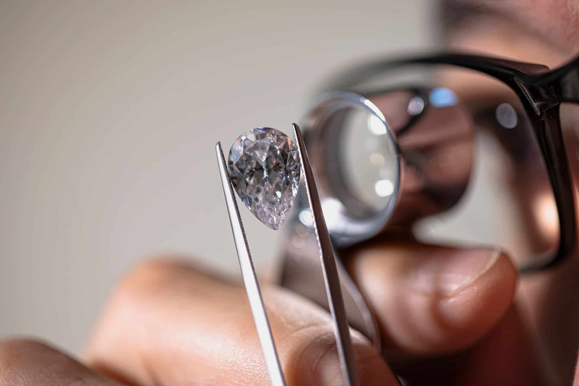 Gemologist looking at a diamond through a loop.